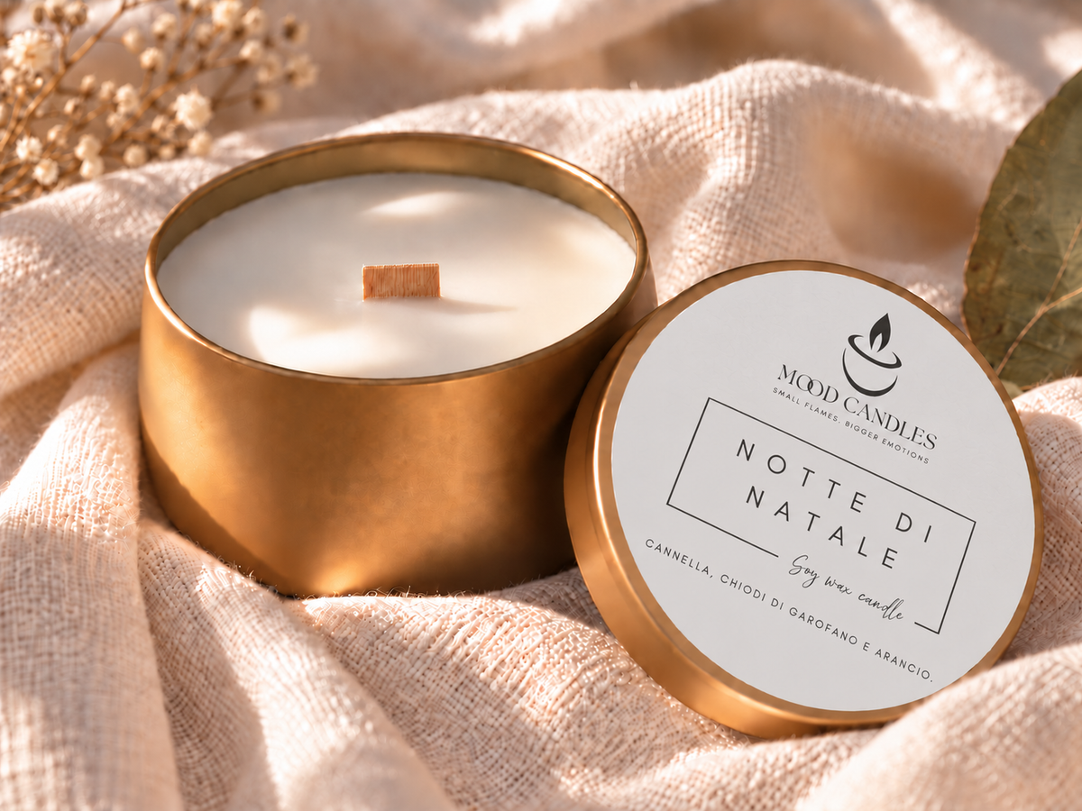 Candela Aurea Notte di Natale di Mood Candles con stoppino in legno largo, contenitore dorato e coperchio con note di cannella, chiodi di garofano e arancio.